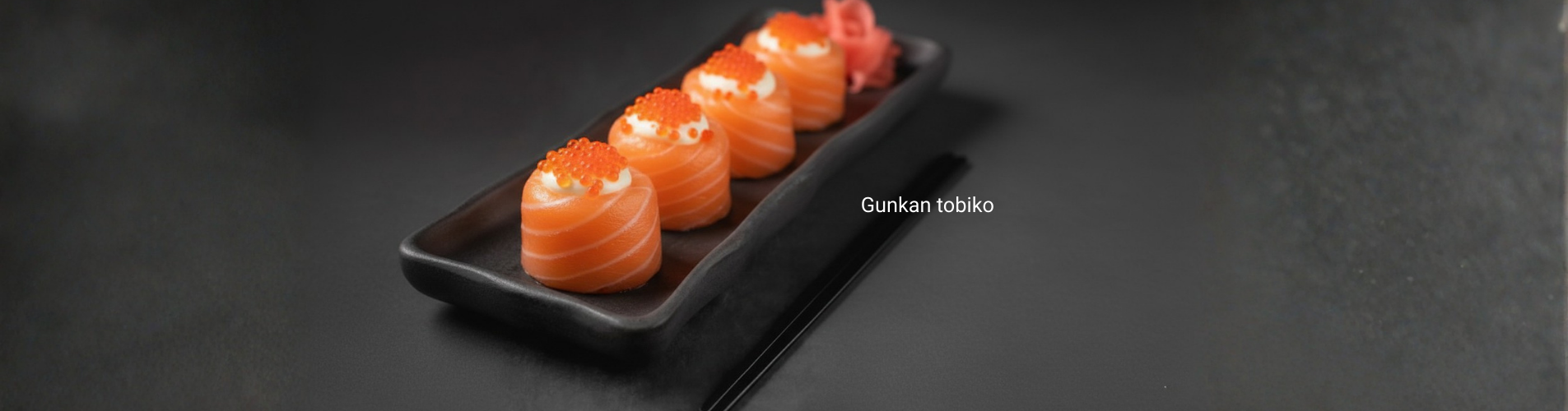 Close-up del Gunkan tobiko mostrando la estructura (shari, nori, topping). Fondo suave, brillo controlado en el menu Infinity.