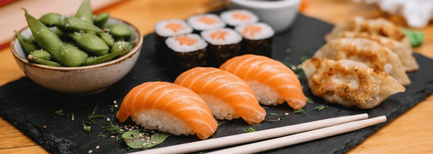 Imagen interna del blog con una selección sencilla de nigiri de salmón, hosomaki, edamame y gyozas servidos juntos. Refuerza la idea de empezar con sabores fáciles y reconocibles durante la primera vez en Sushisom, disfrutando el Menú Infinity sin complic